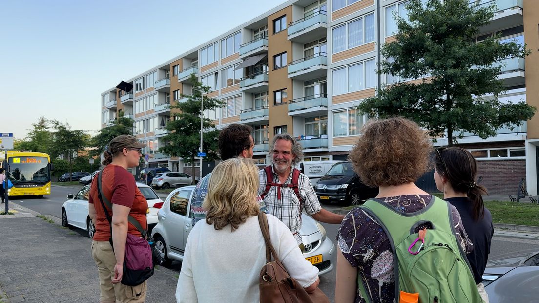Mensen staan rondom hovenier Rob van Steen tijdens de buurtsafari in kanaleneiland